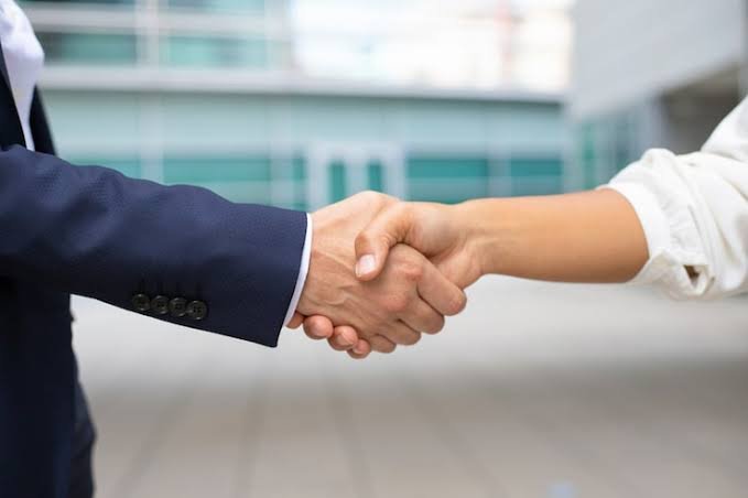 Handshake encircled by interlocking gears, flanked by rising charts, with labels: Outcome Alignment, Transparent Metrics, Risk Sharing, and True Partnership